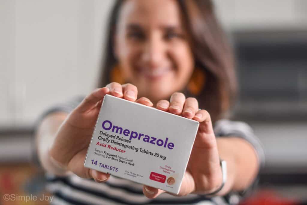 woman holding a box of omeprazole