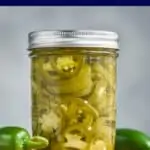 small mason jar filled with pickled jalapeños, yellow green in color and packed in liquid