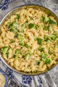 close up overhead view of broccoli pasta recipe made with shells, broccoli florets, red pepper flakes and freshly grated parmesan cheese