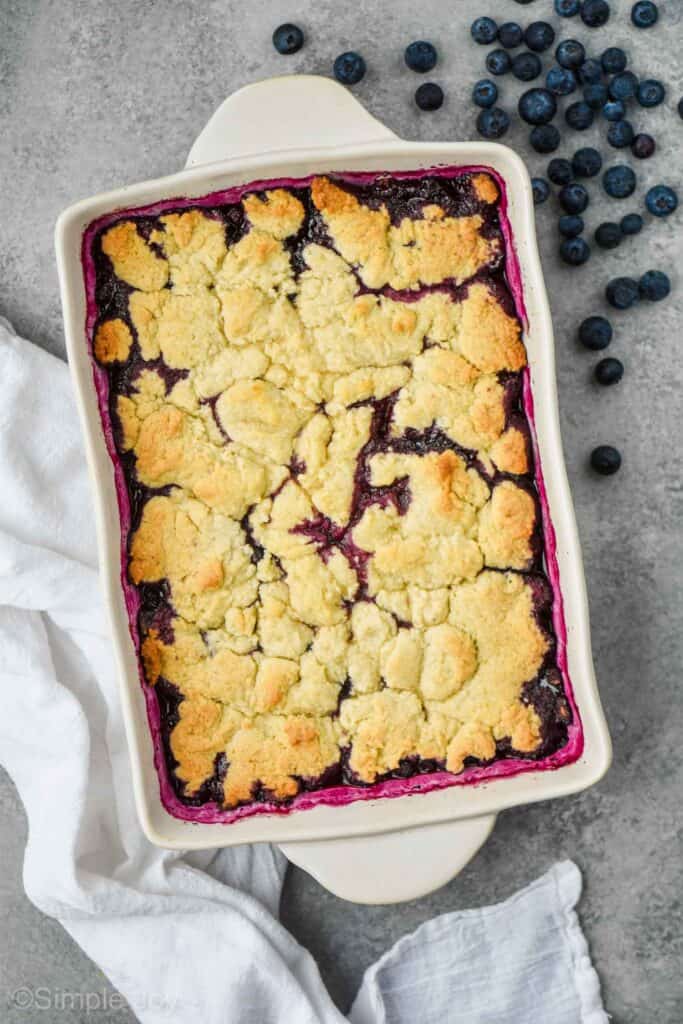 pulled back overhead view of ceramic baking dish full of blueberry cobbler