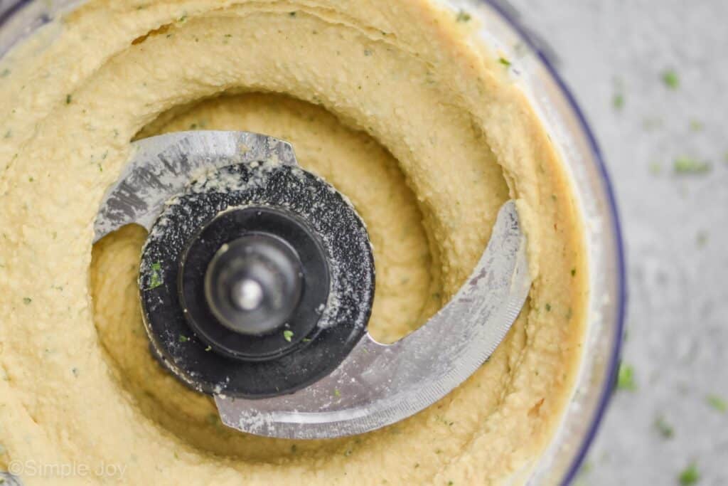 close up of a food processor that has blended hummus smooth
