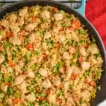 overhead close up view of teal skillet filled with chicken fried rice on a wire cooling rack with a red napkin