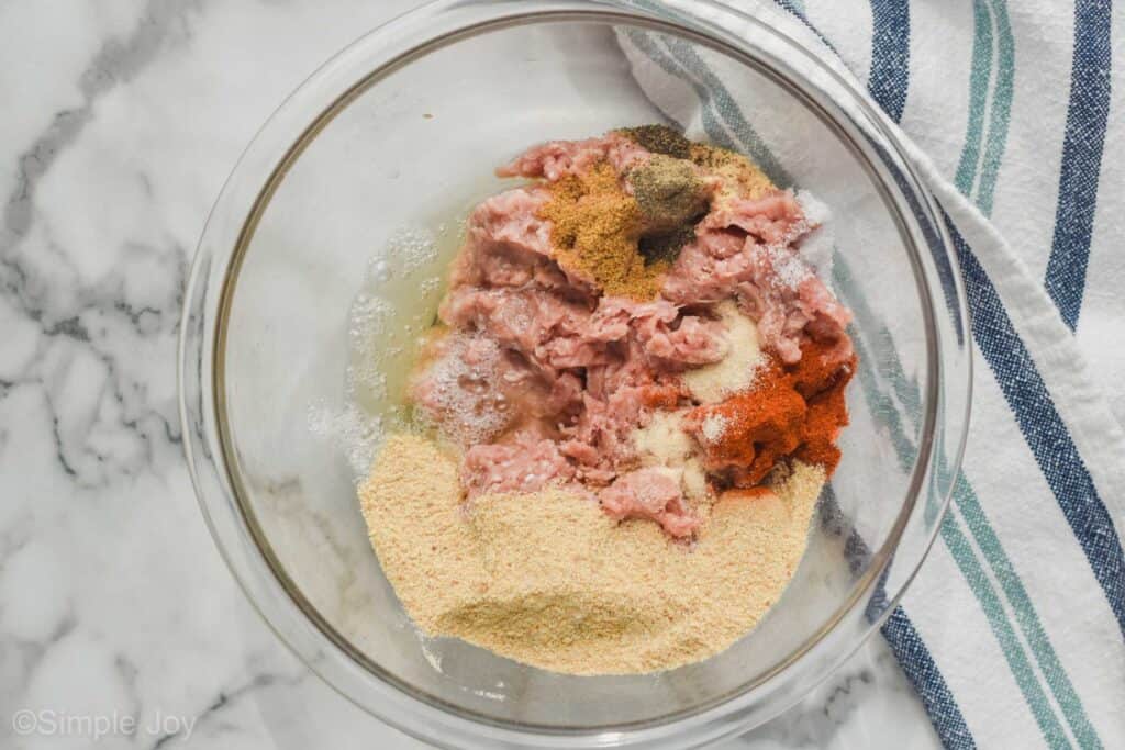 a bowl full of ground turkey, seasonings, egg whites, and bread crumbs to make a turkey burger recipe
