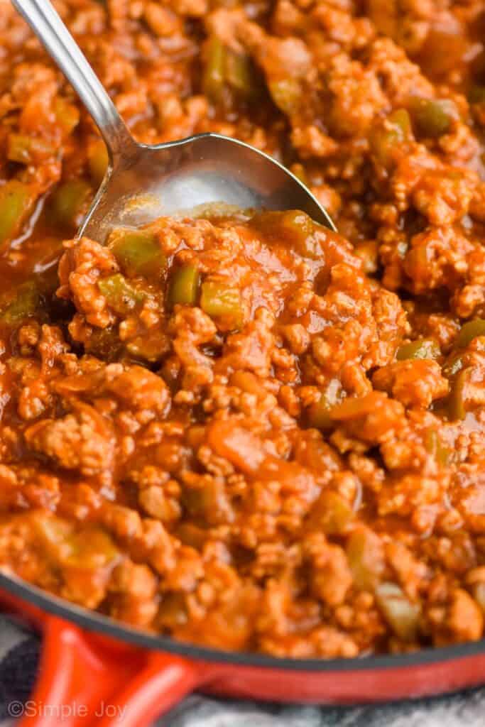 close up of a metal spoon dishing up ground turkey sloppy joes