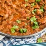 pinterest graphic of the side view of a pan full of beef curry recipe