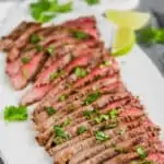 a grilled flank steak cooked and cut into thin slices with cilantro on top