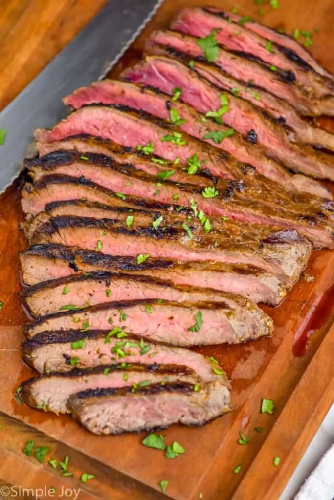 a grilled flank steak, sliced on a cutting board