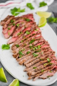 a grilled flank steak cooked and cut into thin slices with cilantro on top