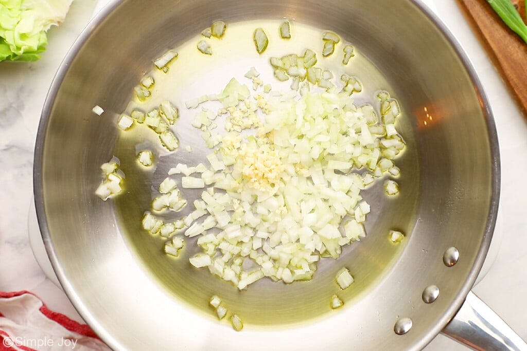 overhead of garlic and onion sautéing for chicken lettuce wraps - 2