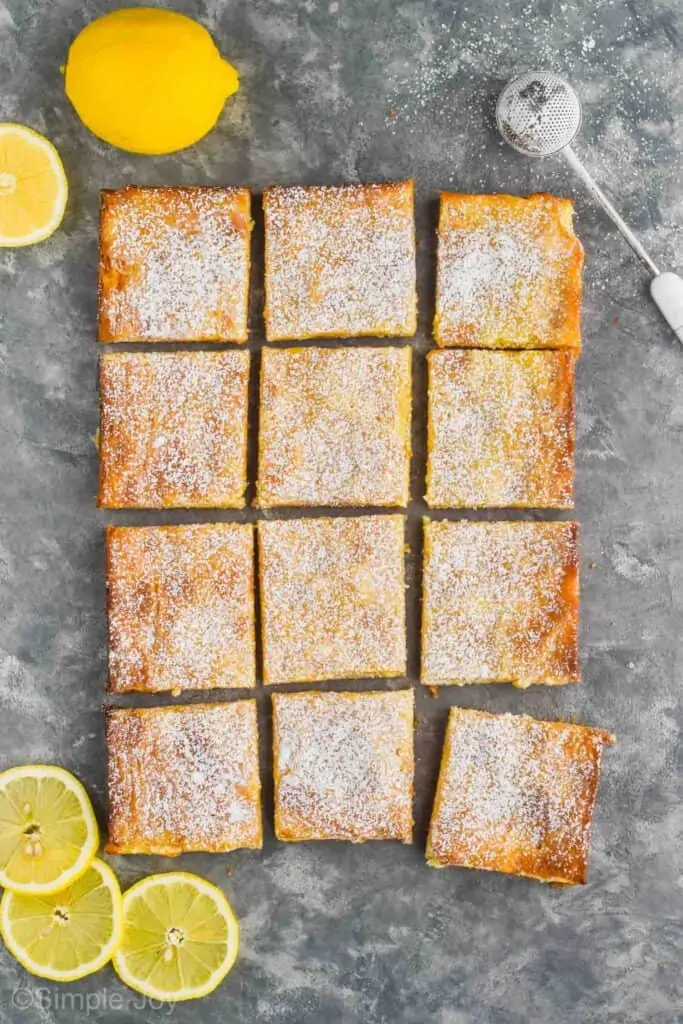 overhead of a full batch of lemon magic bars topped with powdered sugar cut into 12 squares