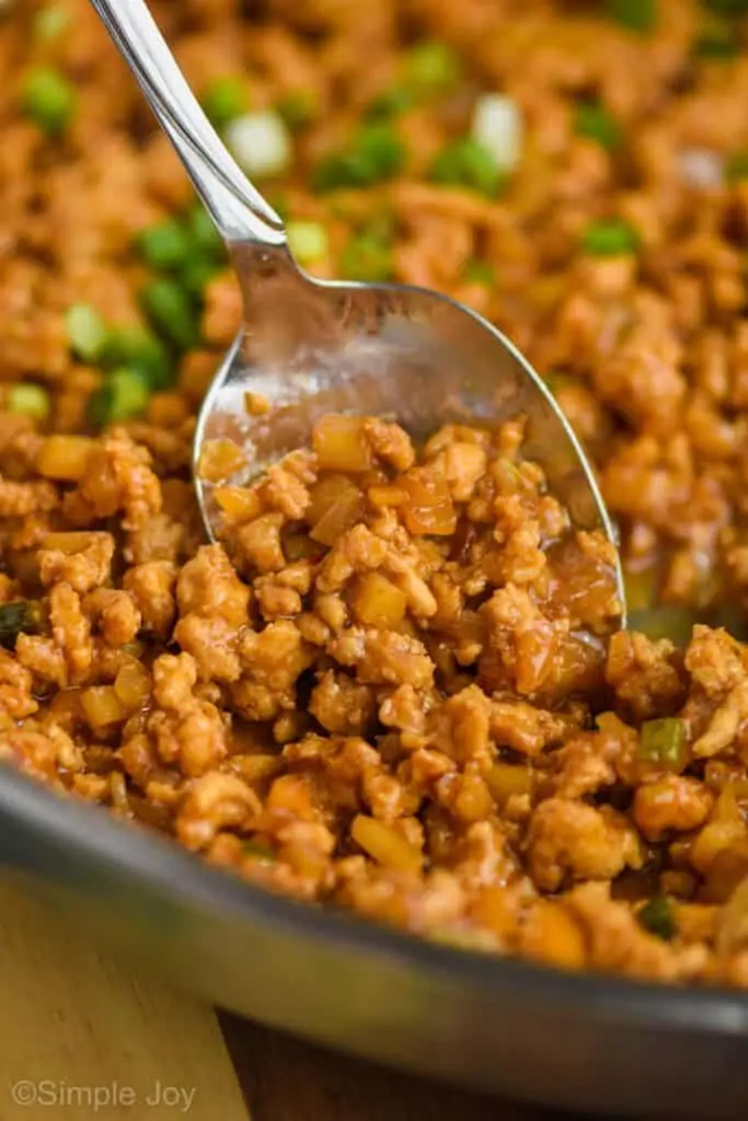 close up of a spoon dishing up the filling for pf Changs chicken lettuce wraps