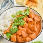 crockpot butter chicken recipe in a bowl with rice and garnished with fresh cilantro - 6