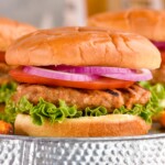 Close up photo of Turkey Burger served on a bun garnished with lettuce, tomato, and onion.