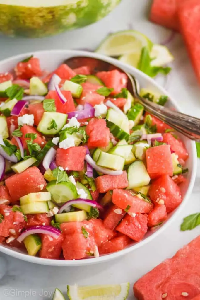 close up side view of a watermelon feta salad with fresh mint, red onions, and cucumber
