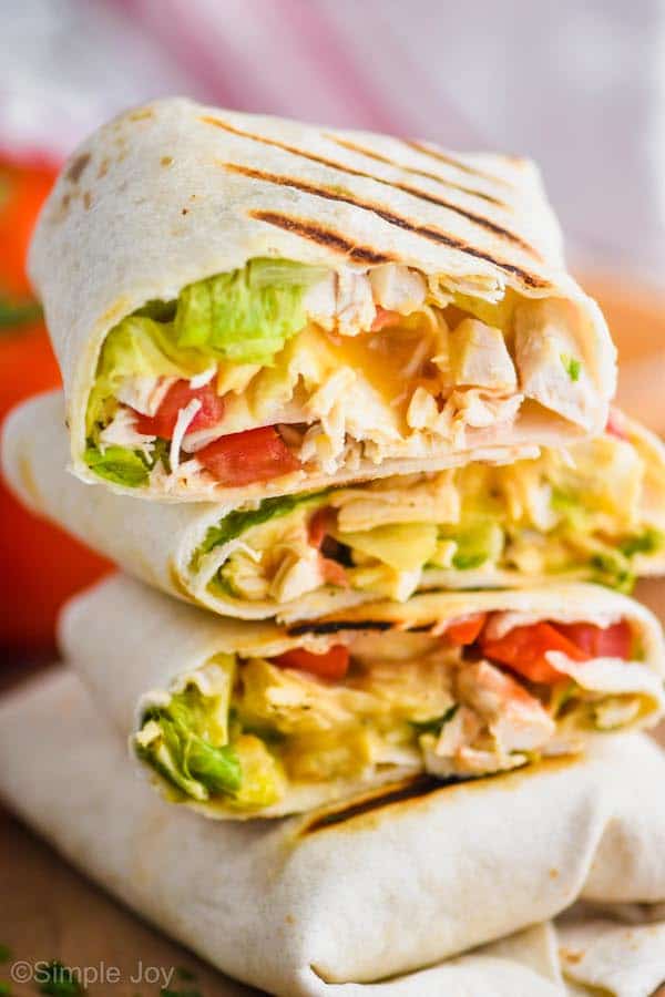 three stacked chicken wraps that have been cut in half and you can see ingredients inside after cooking