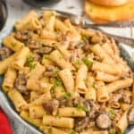 plate of beef and noodles recipe made with rigatoni noodles, ground beef, and mushrooms garnished with parsley
