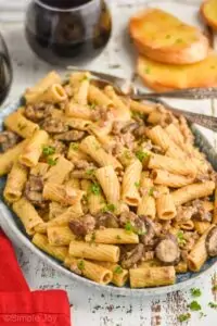 plate of beef and noodles recipe made with rigatoni noodles, ground beef, and mushrooms garnished with parsley