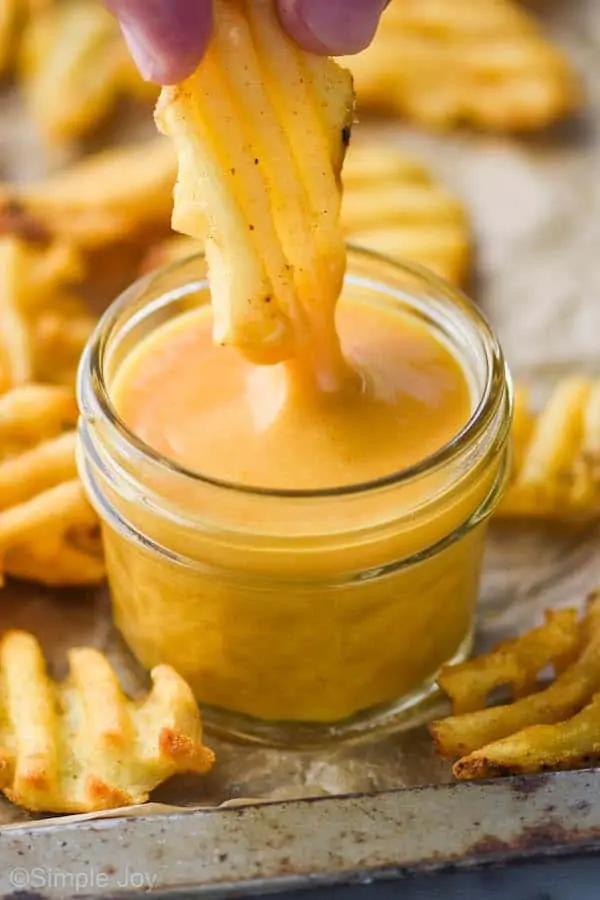 a waffle fry dipping into chick fil a sauce