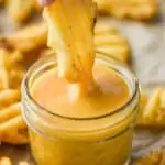 a waffle fry dipping into chick fil a sauce