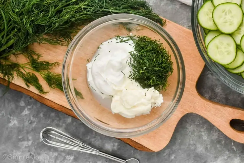 overhead view of a small bowl with the ingredients to make creamy cucumber salad dressing