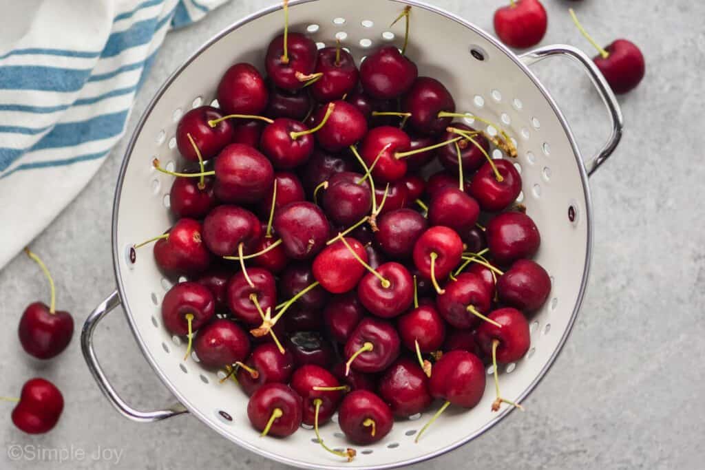 overhead view of fresh cherries in a white colander