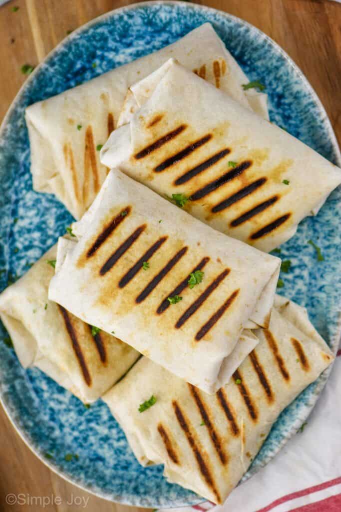 five grilled chicken wraps on a serving platter