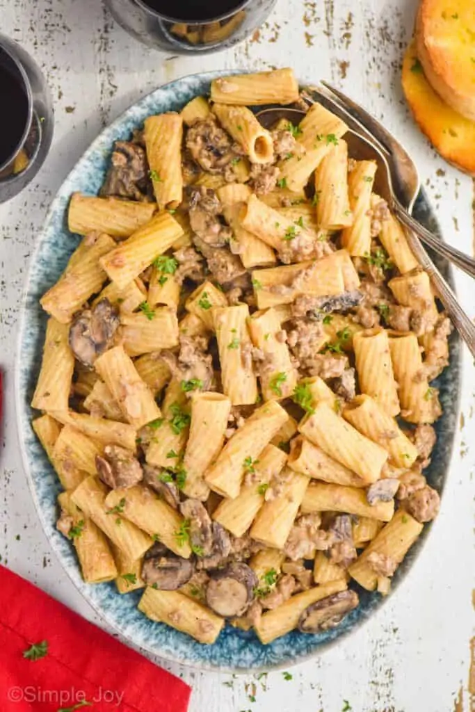 overhead view of an oval plate that is holding ground beef and noodle recipe garnished with parsley