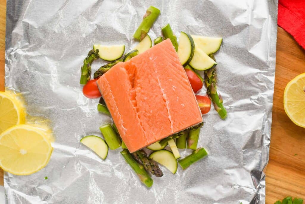 salmon prepared to be cooked in a foil packet with vegetables,
