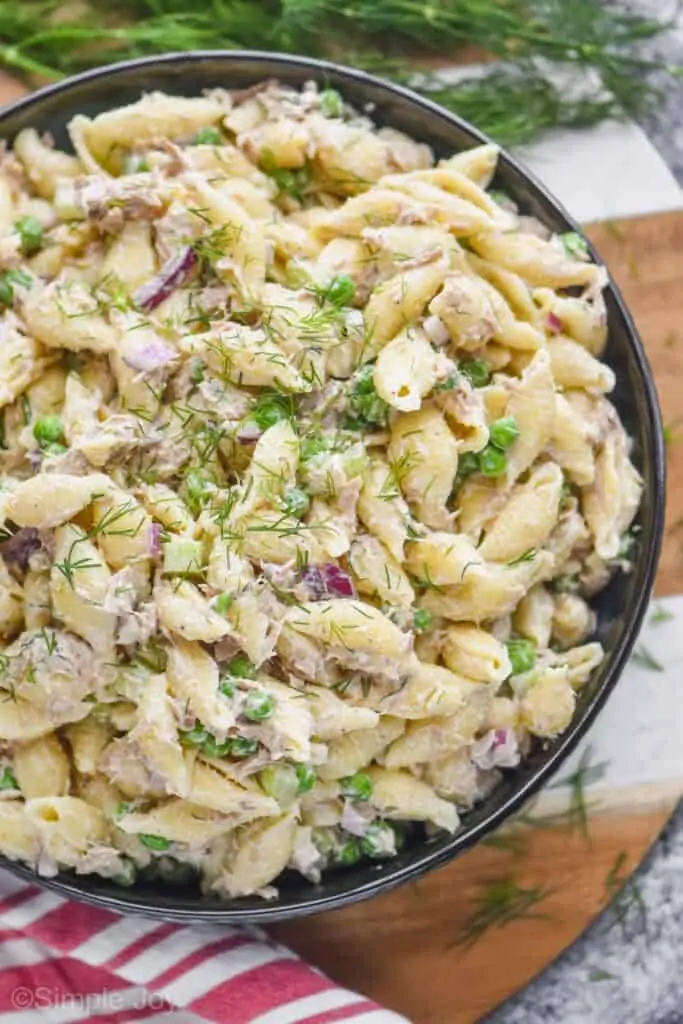 overhead photo of a big bowl of tuna pasta salad garnished with fresh dill