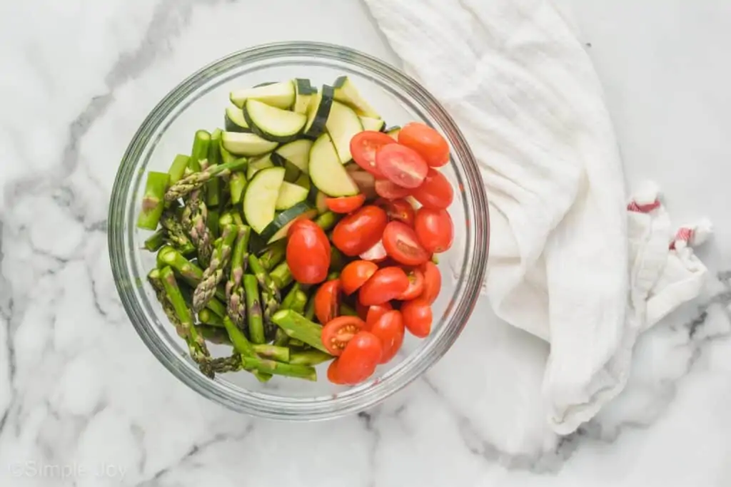 overhead of bowl of zucchini asparagus and tomatoes