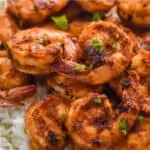 blackened shrimp recipe over white rice garnished with parsley bits