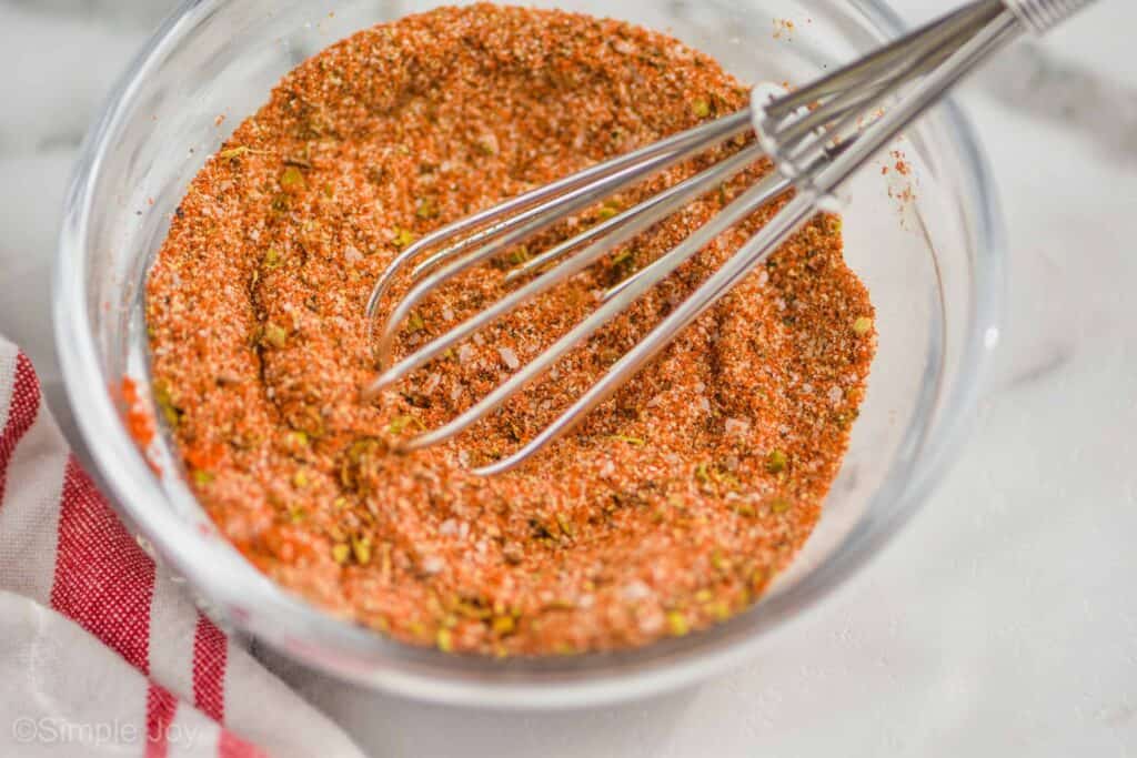 small bowl of cajun seasoning with a tiny whisk in it