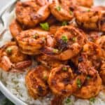 blackened shrimp recipe over white rice garnished with parsley bits