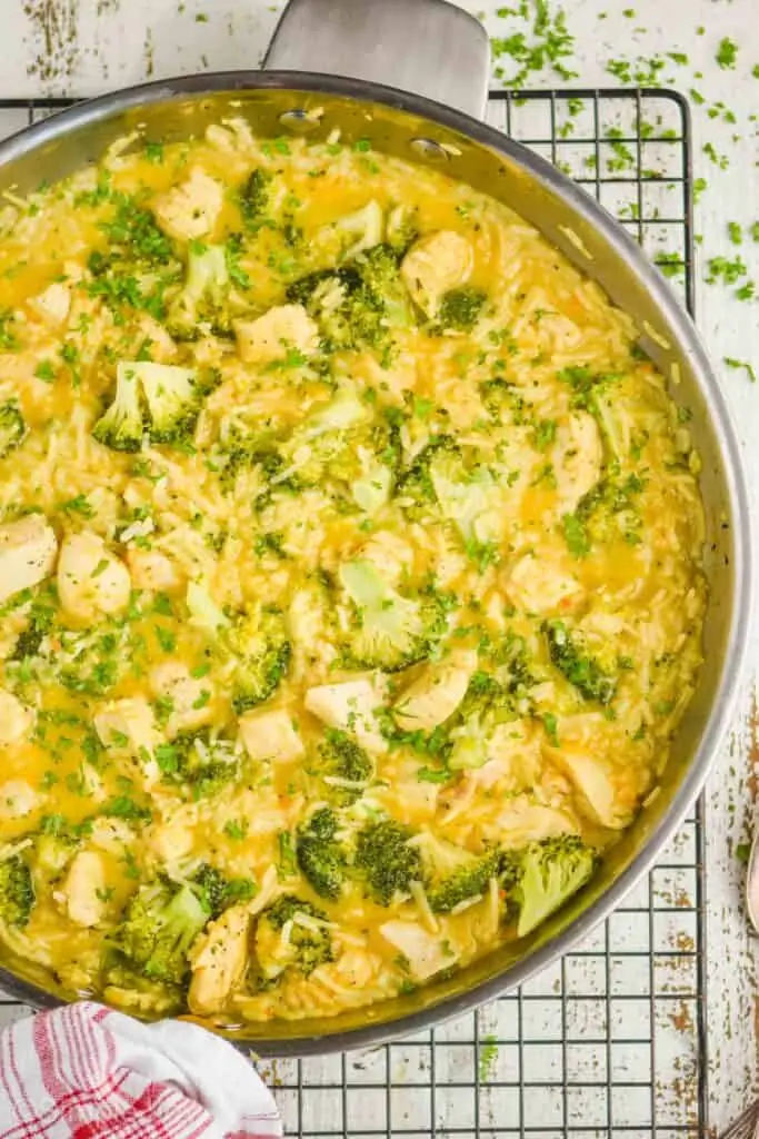 overhead view of a chicken and broccoli casserole in a skillet garnished with fresh parsley