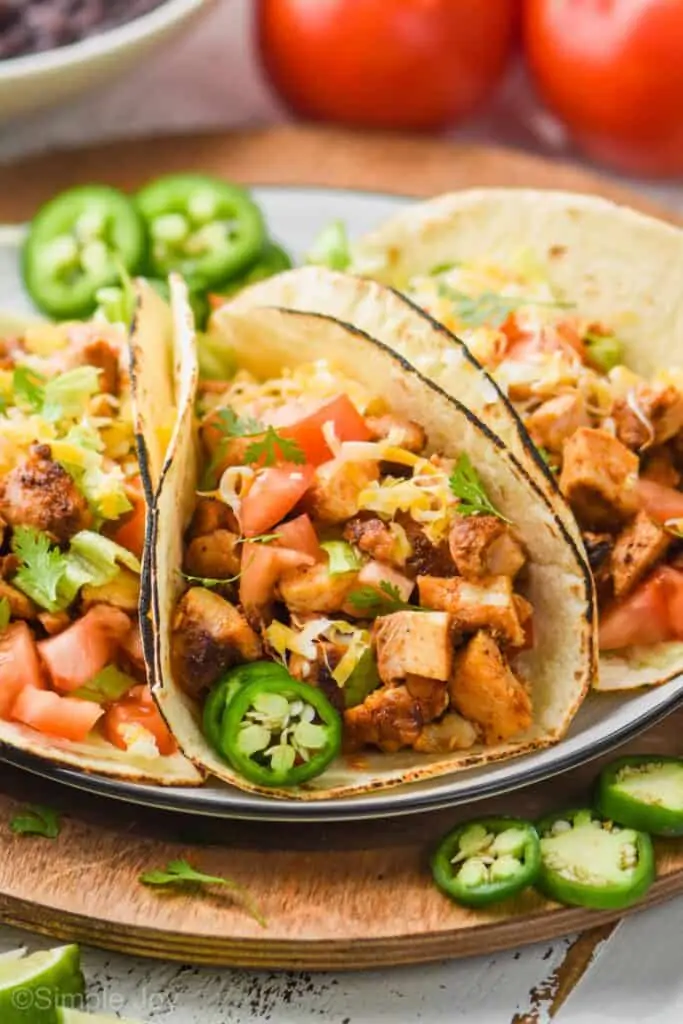 close up of a chicken taco on a plate with fresh jalapeño slice