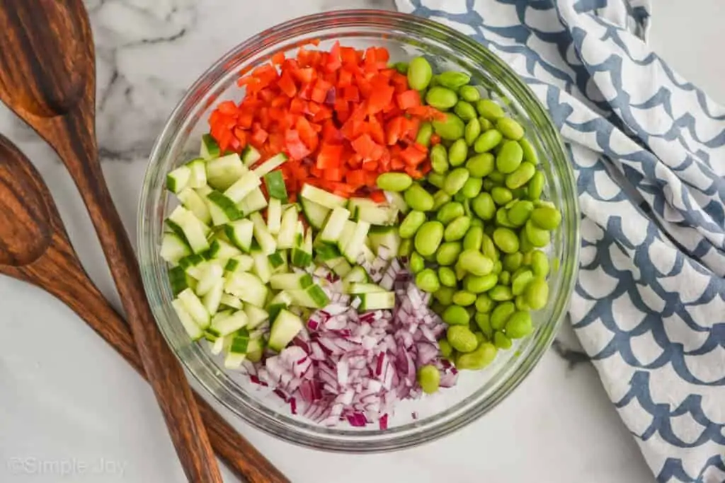 overhead of a bowl of ingredients for edamame salad, separated by ingredients