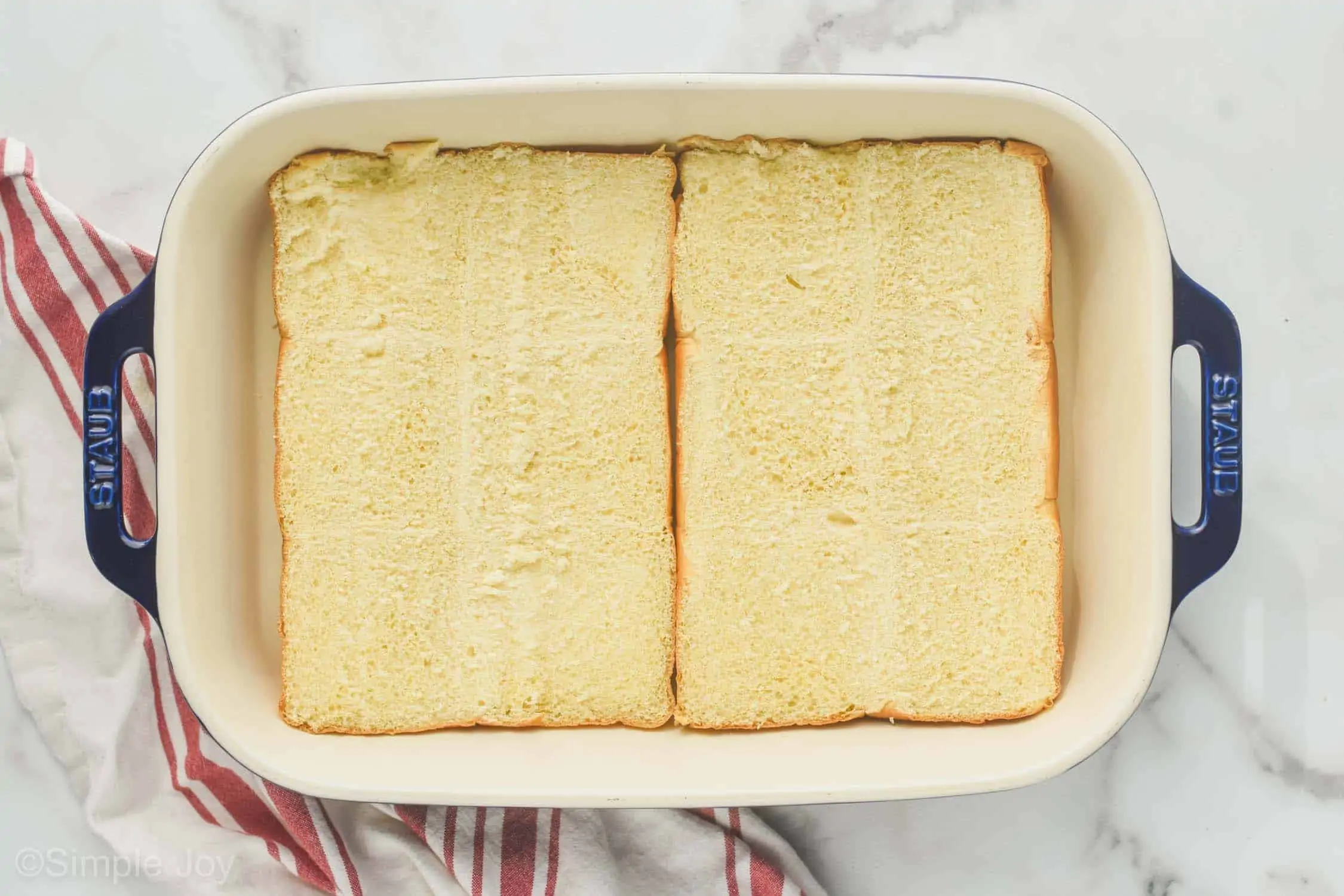 overhead of bottom half of rolls in a baking dish to make ham and cheese sliders