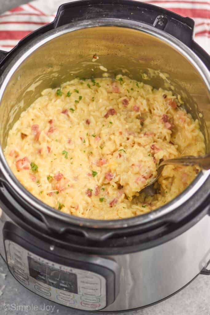 an instant pot with risotto in it and a spoon dishing into it