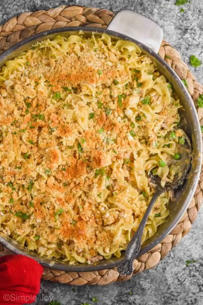 overhead view of a skillet full of tuna noodle casserole with a spoonful missing