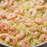side view of a skillet full of shrimp scampi with angel hair pasta