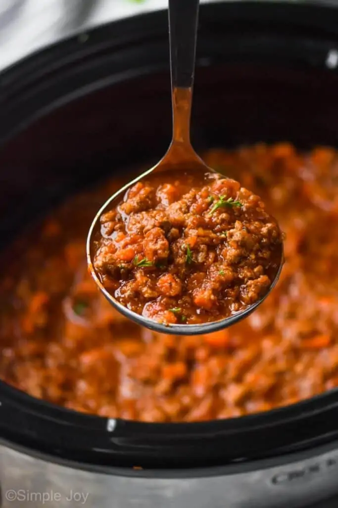 bolognese sauce recipe being ladled out of a slow cooker