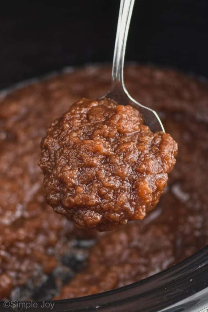 a big spoonful of crockpot apple butter coming out of the slow cooker