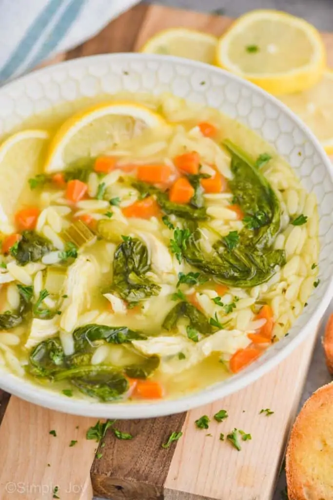 side view of a bowl of lemon chicken orzo soup