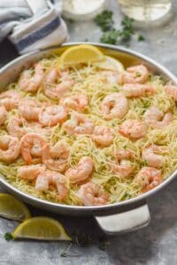 side view of a skillet full of shrimp scampi with angel hair pasta
