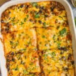 overhead of beef enchilada casserole cut into pieces in baking dish