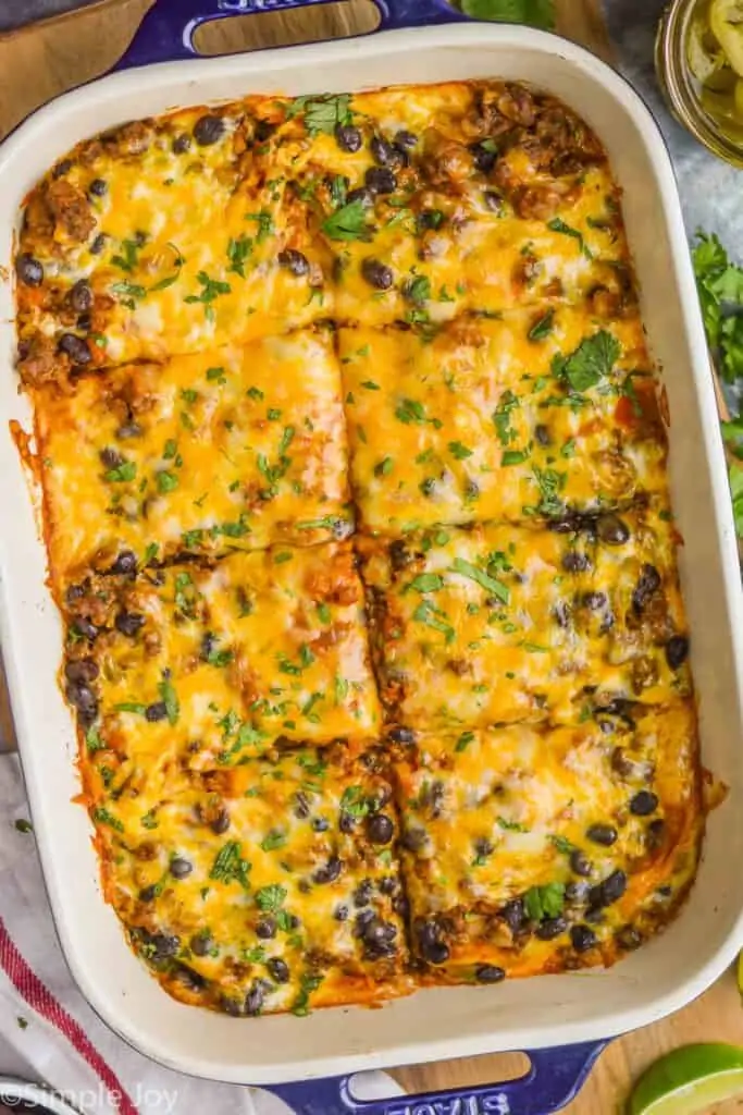 overhead of beef enchilada casserole cut into pieces in baking dish