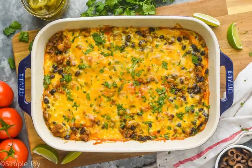 overhead view of ground beef enchilada casserole in a baking dish garnished with chopped cilantro