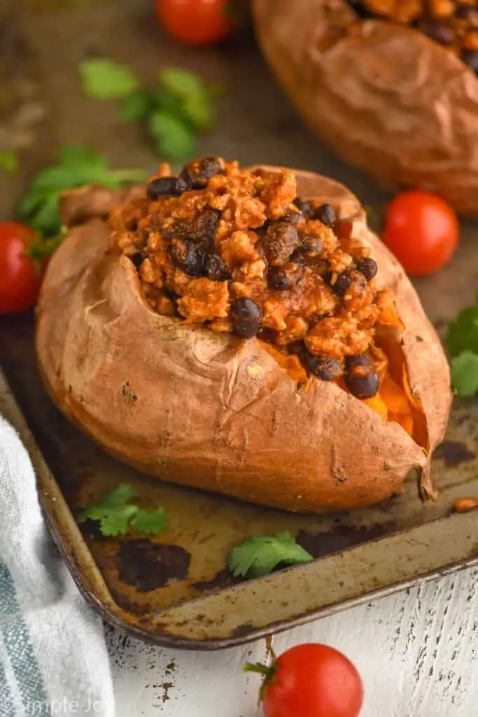 a whole sweet potato that has been split in half and topped with taco meat and black beans