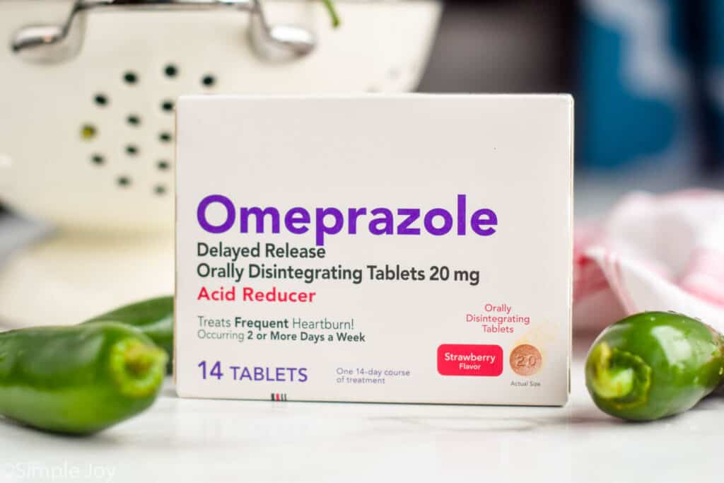 box of omeprazole in front of a strainer