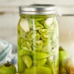 mason jar of pickled green cherry tomatoes and larger tomatoes